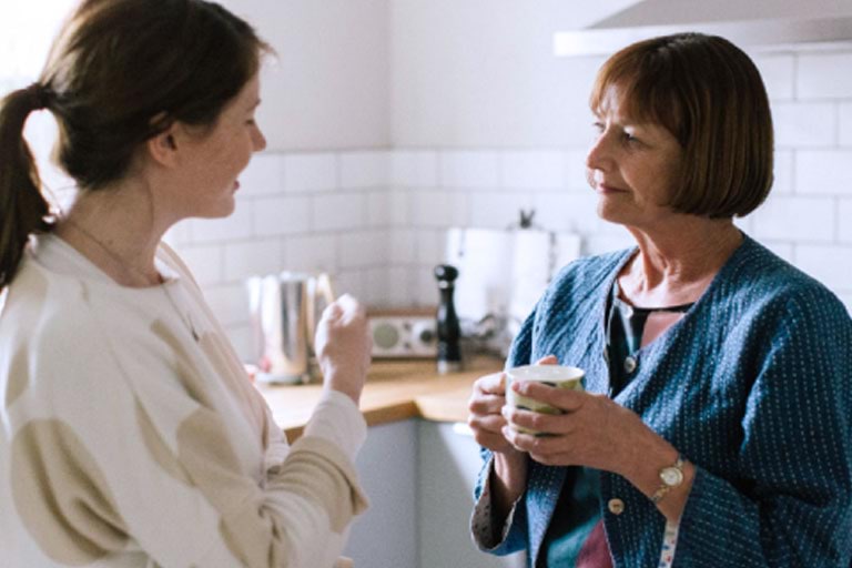 Two women in conversation in a kitchen